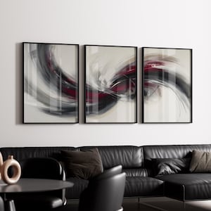 Pode incluir: Conjunto de três impressões de arte abstrata emolduradas. Cada impressão apresenta um design em redemoinho em tons de cinza, preto e bordô contra um fundo neutro. As molduras são pretas e a obra de arte é exibida em uma parede branca.
