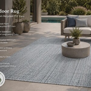 May include: A light blue outdoor rug made from recycled PET yarn. The rug is weather-resistant, mold and mildew resistant, and easy to clean. The rug is UV stabilized for long-lasting color. The rug is shown with outdoor furniture.