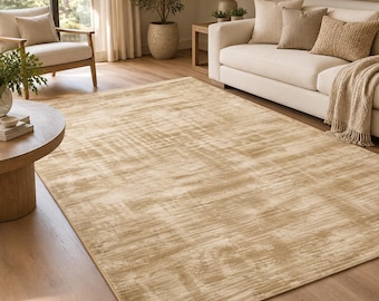 May include: A large rectangular area rug featuring a textured, distressed appearance in shades of light beige and tan. The rug has a subtle, horizontal linear pattern across its surface, creating a soft, weathered look that covers the floor space.