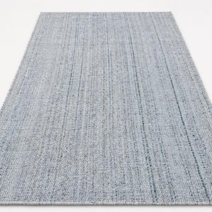 May include: A rectangular, light blue rug with a textured weave. The rug has a subtle pattern of vertical lines, creating a simple yet elegant design. The rug is suitable for various interior spaces.