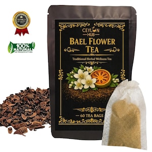 May include: A black pouch of Ceylon Hub Bael Flower Tea containing 60 tea bags. The label features white flowers, a sliced bael fruit, and gold decorative borders. Beside the pouch are loose dried tea pieces and a single white tea bag.
