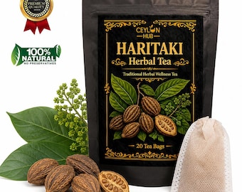 Puede incluir: Una bolsa negra de infusión Haritaki Herbal Tea de Ceylon Hub con 20 bolsitas. La etiqueta muestra texto dorado, una ilustración de frutos de haritaki marrones y hojas verdes. Una bolsita de té beige se sitúa junto a la bolsa.