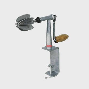May include: A manual coconut grater featuring a silver-toned metal body with a textured finish, a rotating crank handle with a wooden grip, and a sharp, multi-bladed circular head. The device includes a C-clamp base for secure attachment.