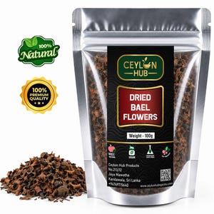 May include: A silver stand-up pouch containing 100g of dried bael flowers, labelled Ceylon Hub. The label features the text Dried Bael Flowers, Weight - 100g, and company contact details. A pile of the dark brown, dried floral pieces sits in front.