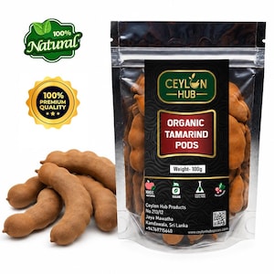 May include: A clear plastic pouch containing 100g of organic tamarind pods with a black label reading Ceylon Hub Organic Tamarind Pods. Several loose, brown, curved tamarind pods are arranged in front of the pouch, alongside 100% Natural and 100% Premium Quality gold and green circular badges.