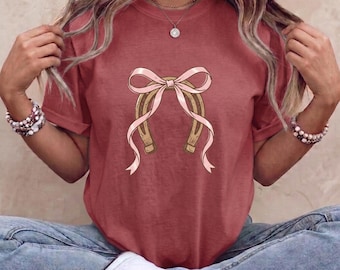 T-Shirt mit kokettem Western-Hufeisenmotiv und Schleife, verspieltes Cowgirl-Shirt im Küstenstil, Retro-Shirt mit rosa Schleife in ästhetischen Wohlfühlfarben