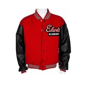 Op de afbeelding: Rode en zwarte varsity-jas met de naam "Elvis" geborduurd op de borst. De jas heeft zwarte leren mouwen, een gestreepte kraag en de woorden "IN CONCERT" onder de naam.