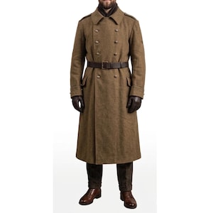 Könnte beinhalten: Ein langer, olivgrüner Wollmantel mit doppelreihigem Design. Der Mantel hat einen braunen Ledergürtel, dunkle Handschuhe und einen hohen Kragen. Er hat mehrere Knöpfe und Taschen und wird mit braunen Hosen und Schuhen getragen.
