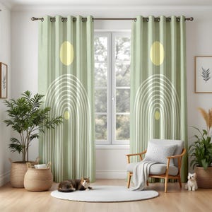 Puede incluir: Cortinas verde salvia con un diseño geométrico blanco con arcos y círculos amarillos. Las cortinas cuelgan frente a una ventana, con una silla, plantas y un gato en la habitación. Las cortinas son de tela suave y texturizada.