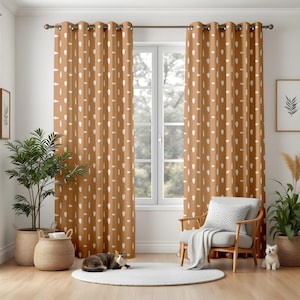 May include: Brown curtains with a white teardrop design are displayed in front of a window. The curtains are suspended from a dark metal rod. A white rug, a wooden chair, and potted plants are in front of the window.