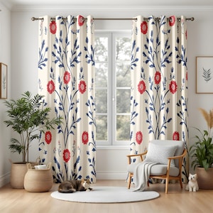 May include: Cream-coloured curtains featuring a repeating pattern of red flowers and blue leaves. The floral design is symmetrical, with the flowers and leaves arranged vertically. The curtains are hanging in front of a window.