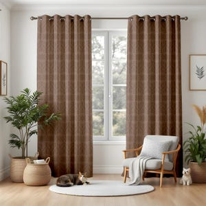 May include: Brown patterned window curtains with grommets, hanging from a dark metal rod. The curtains are closed, and the pattern is a repeating design. The room has a window, a chair, and plants in baskets.