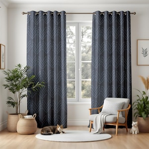 May include: Dark blue curtains with a repeating geometric pattern of light blue chevrons. The curtains are hanging on a rod above a window. The room has a neutral color palette with a white rug, a wooden chair, and plants in woven baskets.