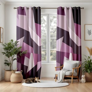May include: A pair of curtains with a geometric pattern in shades of purple, lilac, and black. The design consists of angled shapes and lines. The curtains are suspended from a metal rod. A chair, rug, and plants are in front of the curtains.