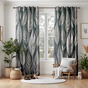 May include: A pair of teal and white feather-patterned curtains hang in front of a window. The curtains feature a repeating design of large, stylized white feathers against a teal background. The curtains are hung on a dark metal rod.