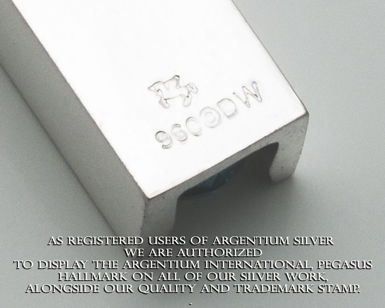 May include: Close-up of a silver hallmark stamp with the text "9600DW" and a stylized horse design. The text "AS REGISTERED USERS OF ARGENTIUM SILVER WE ARE AUTHORIZED TO DISPLAY THE ARGENTIUM INTERNATIONAL, PEGASUS HALLMARK ON ALL OF OUR SILVER WORK, ALONGSIDE OUR QUALITY AND TRADEMARK STAMP." is visible below the stamp.
