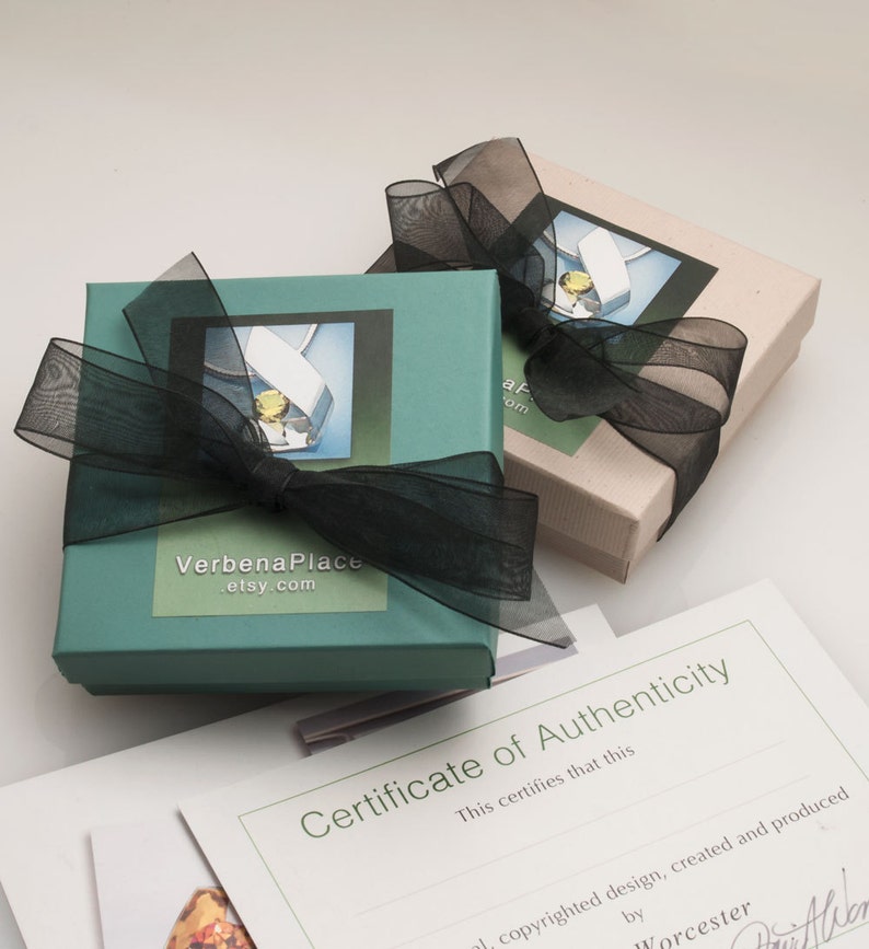 May include: Two teal and beige gift boxes with black ribbon bows. The boxes have a white label with the text "VerbenaPlace etsy.com". A certificate of authenticity is visible in the background.