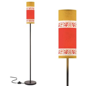 May include: A tall floor lamp with a cylindrical lampshade. The lampshade features a mustard yellow top and bottom, with a red center section. A white floral and bird pattern decorates the edges. The lamp has a black metal pole and base.