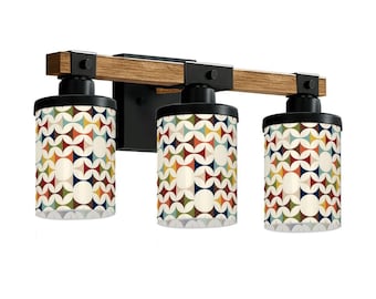 May include: A three-light vanity fixture with a wood-look beam and black metal accents. The cylindrical shades feature a retro geometric pattern in shades of red, yellow, blue, and green. The fixture is designed for wall mounting.