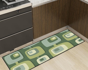 May include: A rectangular kitchen rug with a retro geometric pattern in shades of green, blue, and cream. The rug is placed in front of a stove and cabinets, adding a decorative element to the kitchen.