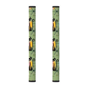 May include: Two cylindrical objects with a retro cat design. The objects have a light green background with a repeating pattern of starbursts and stylized black cats with yellow and pink accents. The ends are black.