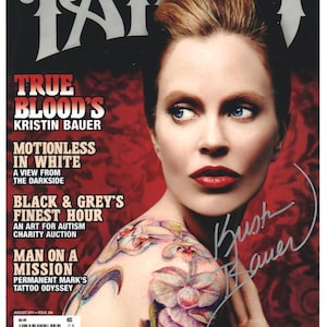 Könnte beinhalten: Tattoo Magazin Ausgabe 264 vom August 2011 mit Kristin Bauer auf dem Cover. Das Cover zeigt den Text True Blood's Kristin Bauer, Motionless in White und Black & Grey's Finest Hour. Ein buntes Orchideen-Tattoo ist auf der Schulter zu sehen.