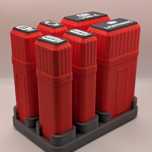 May include: A set of six red rectangular charging cable organizers with black labels, each labeled with a different cable type, including "Lightning", "USB C", and "Micro". The organizers are arranged on a gray rectangular base.