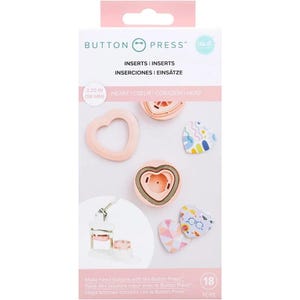 May include: Button Press inserts for making heart-shaped buttons. The package includes various pink inserts, with a 2.25-inch (58 mm) size indicator. The design features the text "HEART" in multiple languages and includes 18 pieces.