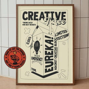 May include: A framed poster with a cream-colored background features a cartoon milk carton design. The text reads "CREATIVE Juice" and "EUREKA!" with the phrase "In case of EMERGENCY drink daily." The poster also includes the text "LIMITED EDITION!" and "750ml".