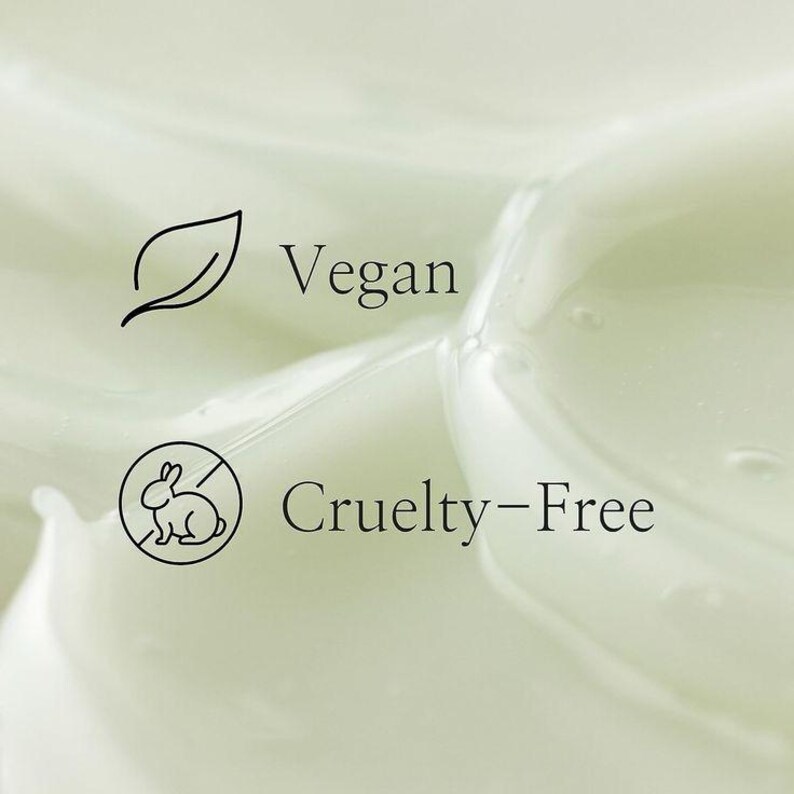 Op de afbeelding: Close-up van een lichtgroene, romige substantie met de woorden "Vegan" en "Cruelty-Free" in zwarte tekst. De tekst "Vegan" staat naast een bladicoon en de tekst "Cruelty-Free" naast een doorgestreept konijnicoon.
