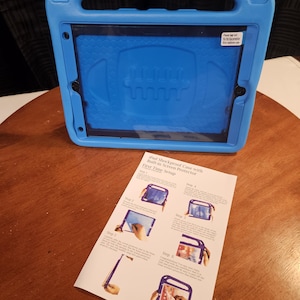 May include: A blue iPad shockproof case with a built-in screen protector. The case has a handle and a football-shaped design on the back. A setup guide is next to the case.