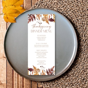 May include: A Thanksgiving dinner menu with a fall-themed floral design. The menu includes starters, main course, side dishes, and desserts. The text reads: "Thanksgiving Dinner Menu".