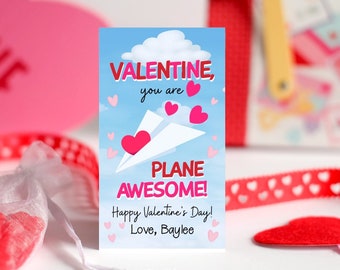 May include: A Valentine's Day card with a blue sky background, a white paper airplane, and pink hearts. The card reads "VALENTINE, you are PLANE AWESOME! Happy Valentine's Day! Love, Baylee."