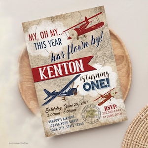May include: A vintage-style airplane themed first birthday party invitation with a red, white, and blue color scheme. The invitation features a red airplane with a white propeller and a blue airplane with a white propeller. The text on the invitation reads "My, oh my... this year has flown by! Kenton is turning one!" and includes the date, time, and location of the party. RSVP information is also included.
