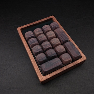May include: A wooden number pad with dark brown keys and a light brown frame. The keys are arranged in a 4x4 grid, with numbers etched on them. The number pad is set against a dark background.