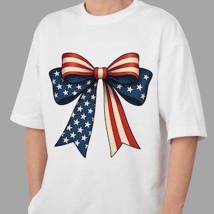 Op de afbeelding: Wit T-shirt met een grote afbeelding van een patriottische strik. Het strikdesign gebruikt de kleuren van de Amerikaanse vlag: rood, wit en blauw. Het ontwerp van de strik bevat sterren en strepen, wat een feestelijke uitstraling creëert.