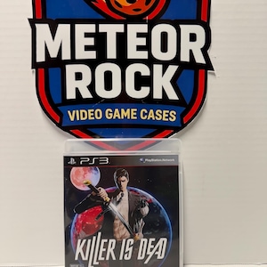 May include: A PlayStation 3 video game case for Killer Is Dead featuring a man in a suit holding a sword against a backdrop of a red moon and planet. Above the case is a shield-shaped sign with a meteor graphic and the text METEOR ROCK.