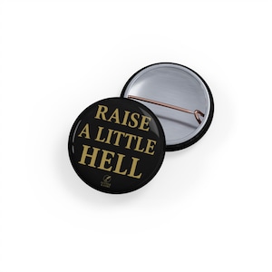 May include: Black button with gold text that reads "Raise a little hell".