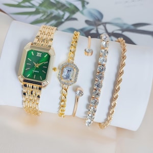 May include: A white ceramic mug with a black handle and the text "But First, Coffee" in a handwritten style. The mug is on a white surface. The mug is approximately 4 inches tall.