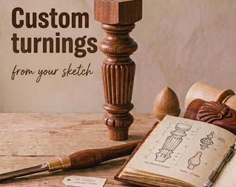 May include: A brown wooden furniture leg with a turned design, featuring a square top and fluted base. Beside it lies an open sketchbook displaying technical drawings of leg profiles and finials, a metal chisel, and a small paper tag labeled Turners Collection.