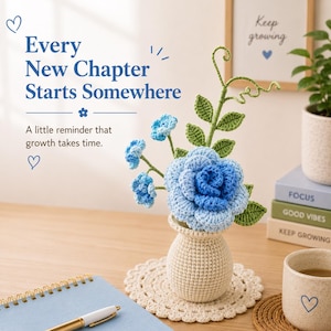 Puede incluir: Una rosa azul tejida a ganchillo y pequeñas flores azules en un jarrón de ganchillo color crema sobre un tapete a juego. El texto dice: Every New Chapter Starts Somewhere. A little reminder that growth takes time. Incluye hojas verdes.
