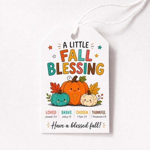 May include: A white rectangular gift tag with a string, featuring the text A LITTLE FALL BLESSING, three cartoon pumpkins in orange, teal, and cream, and the words LOVED, BRAVE, CHOSEN, THANKFUL with Bible verses, ending with Have a blessed fall!