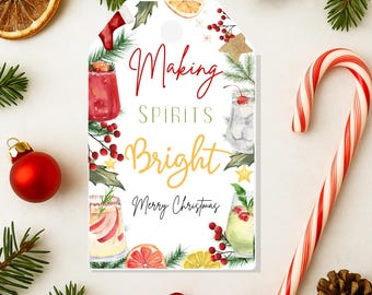 May include: A white gift tag with the words "Making Spirits Bright" and "Merry Christmas" in red and gold script. The tag features watercolor illustrations of cocktails, holly, and a stocking. A red candy cane and Christmas ornaments surround the tag.