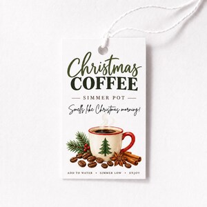 May include: A rectangular white gift tag with a string, featuring the text Christmas COFFEE SIMMER POT Smells like Christmas morning! ADD TO WATER SIMMER LOW ENJOY. The design includes a red and white mug with a green tree, coffee beans, and cinnamon.