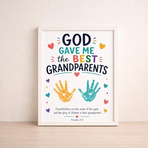 May include: A framed wall art print featuring the text GOD GAVE ME the BEST GRANDPARENTS in blue, green, and red. Below the text are two handprints in yellow and teal, followed by the verse Grandchildren are the crown of the aged, Proverbs 17:6.