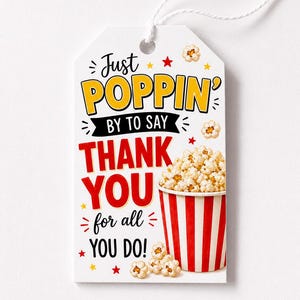 May include: A white gift tag with the text "Just Poppin' By To Say Thank You for all You Do!" in yellow, red, and black. A red and white striped popcorn container is filled with popcorn. Small popcorn kernels and stars are scattered around the tag.
