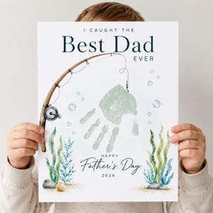 May include: A Father's Day print featuring a handprint design with a fishing rod illustration. The text reads "I Caught the Best Dad Ever" and "Happy Father's Day 2026". The print includes watercolor elements of seaweed and bubbles.