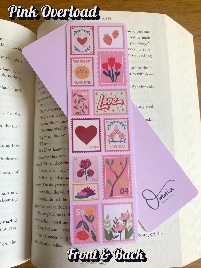 May include: A pink bookmark with a stamp design featuring hearts, flowers, and the words "Love" and "Sunshine." The bookmark is in a book, with the text "Pink Overload" and "Front & Back" visible.