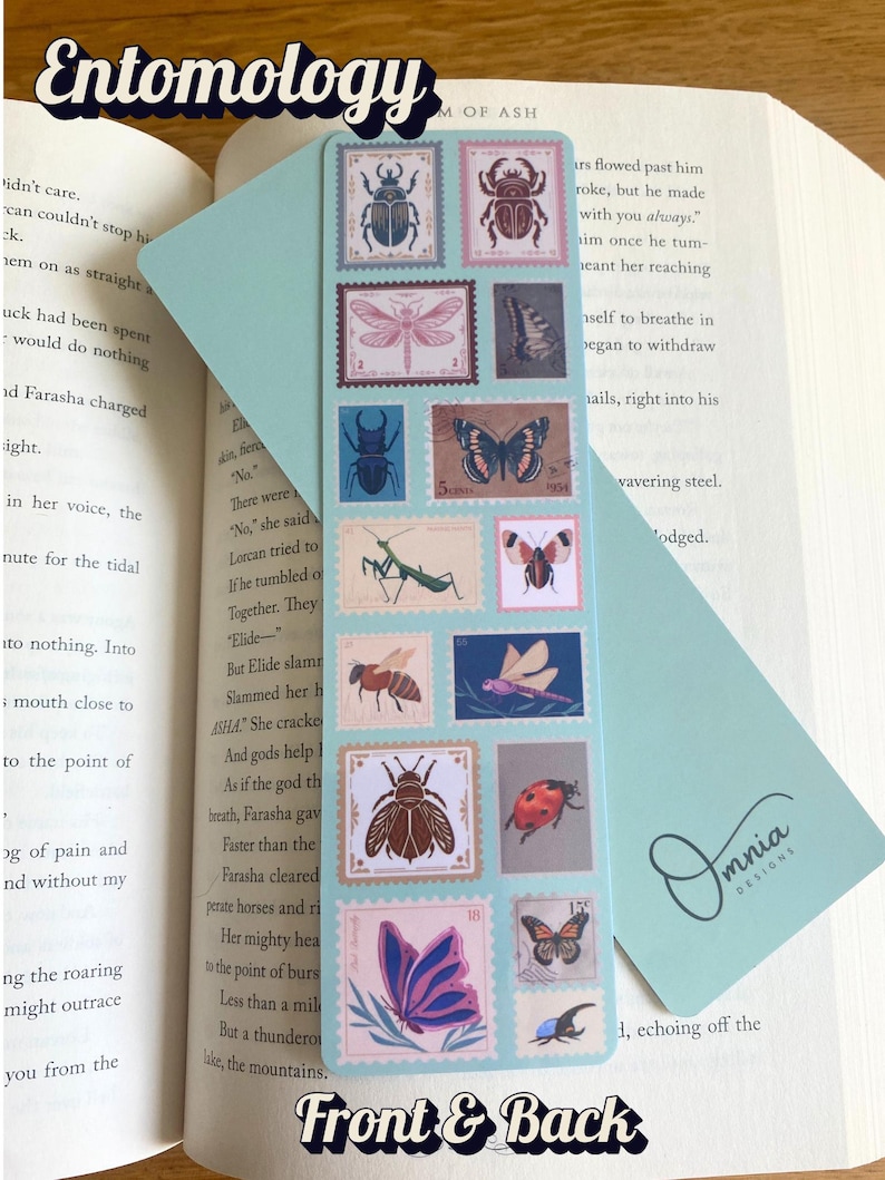 May include: A light blue bookmark with insect illustrations designed as postage stamps. The bookmark has the word "Entomology" at the top and "Front & Back" at the bottom. The bookmark is placed in an open book.