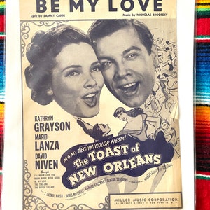 Pode incluir: Uma capa de partitura vintage para a música "Be My Love" do filme "The Toast of New Orleans". A capa apresenta uma fotografia em preto e branco de Kathryn Grayson e Mario Lanza, com o título da música em letras grandes e em negrito.